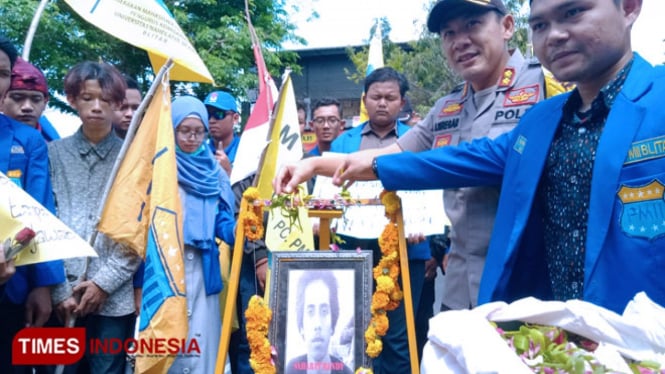 Kapolres Blitar menabur bunga di foto Imawan Randi bersama massa aksi damai PMII Blitar, Senin (30/9/2019). (Foto: Sholeh/ TIMES Indonesia)
