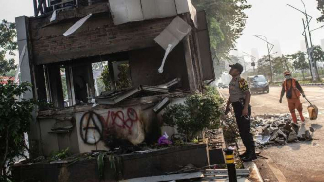 Petugas Polisi dan PPSU beraktivitas di dekat Pos Polisi yang hangus terbakar pascaunjuk rasa mahasiswa di Jalan Gerbang Pemuda, Senayan, Jakarta, Rabu (25/9/2019). 