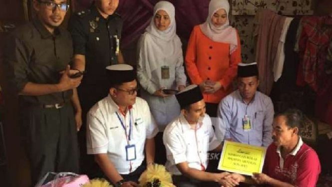 Mohd Zain Abdullah (paling kiri) ketika menerima bantuan.