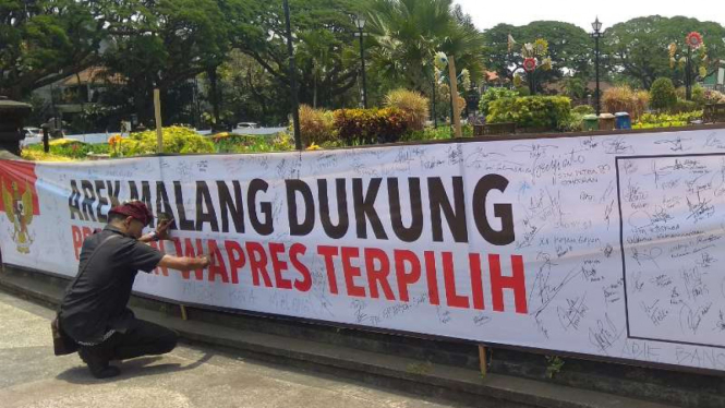 Warga Kota Malang menggalang dukungan berbentuk tanda tangan untuk mendukung pelantikan presiden dan wakil presiden di bundaran monumen Tugu, Senin, 7 Oktober 2019.