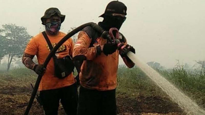 Pemadaman kebakaran lahan dan hutan di Provinsi Riau.