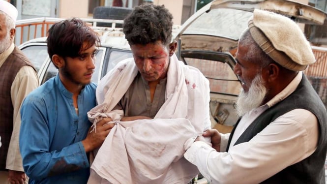 Seorang remaja mendapat pertolongan pertama setelah ledakan berlangsung di sebuah masjid di Provinsi Nangarhar, Afghanistan. - EPA