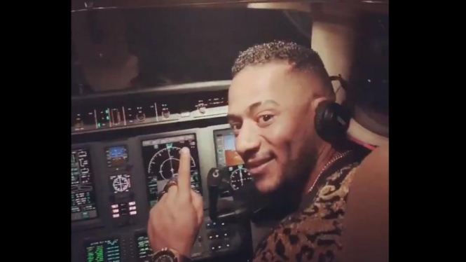 Penyanyi Mesir Mohamed Ramadan mengunggah video dirinya di kokpit pilot ke akun media sosial, membuat sang pilot mendapat sanksi larangan terbang seumur hidup. - Mohamed Ramadan / Twitter