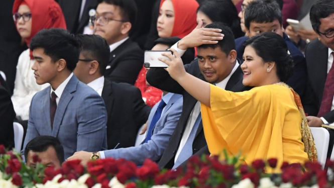 Anak kedua dan menantu Jokowi, yaitu Kahiyang Ayu dan Bobby Nasution berswafoto sebelum seremoni pelantikan. - ANTARAFOTO/AKBAR NUGROHO GUMAY