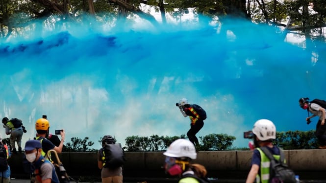 Polisi menembakkan meriam air berisi cairan biru. - Reuters