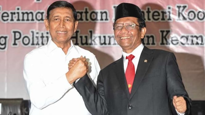 Menko Polhukam Mahfud MD (kanan) berjabat tangan dengan pejabat lama Wiranto saat serah terima jabatan di kantor Kemenko Polhukam, Jakarta, Rabu (23/10/2019).