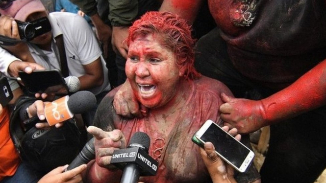 Patricia Arce disiram cat merah dan dicukur rambutnya. - EPA