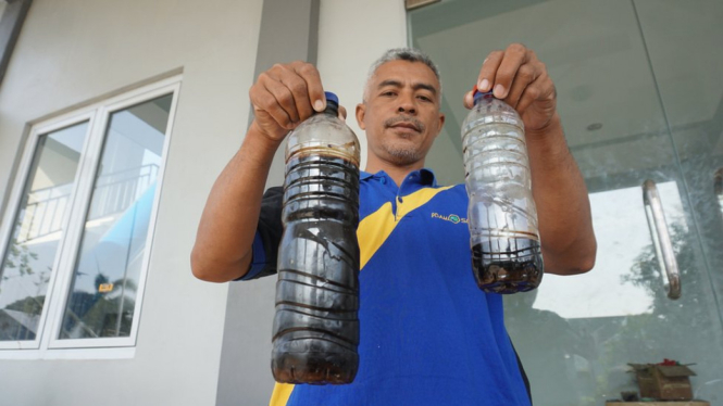 Kepala Instalasi Produksi Wilayah Selatan Perumda Air Minum Toya Wening Solo, Nuryanto, menunjukkan hasil produksi air bersih yang tercemar limbah. - FAJAR SODIQ
