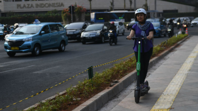 Ilustrasi pengguna skuter listrik di jalanan Jakarta