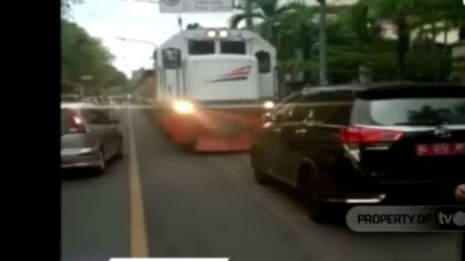 Mobil dinas pemerintah dengan pelat nomor merah terparkir di area rel kereta api di Kota Solo, Jawa Tengah.