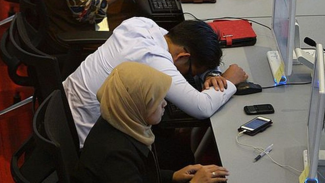 Seorang karyawan tertidur di sebuah kantor. - AFP/Getty Images