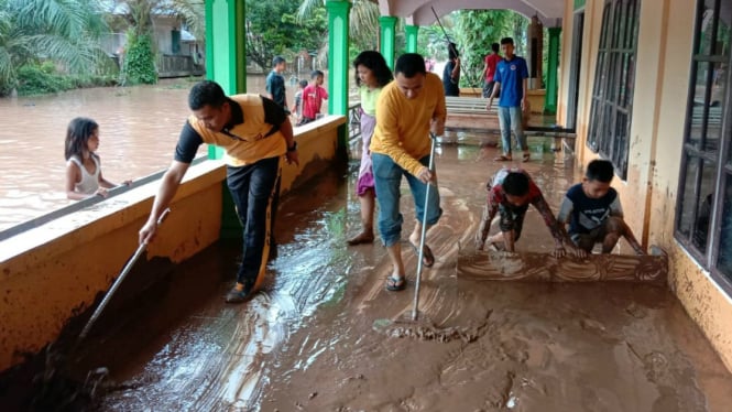 Warga Riau bersihkan area rumah dari lumpur tanah akibat terjangan banjir.