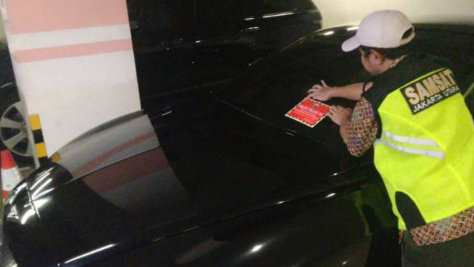 Petugas memberikan stiker di Mobil Mewah Penunggak Pajak di DKI Jakarta.