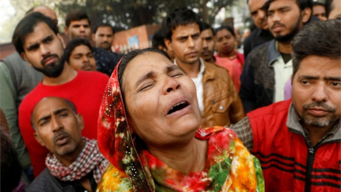 Seorang kerabat korban kebakaran pabrik di Delhi, India, menangis di luar kamar jenazah. - Reuters