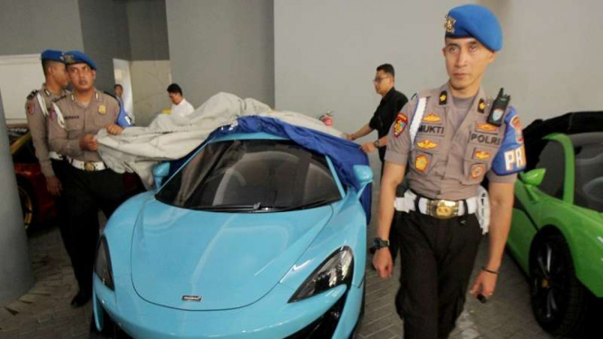 Polisi menjaga sejumlah mobil mewah yang diamankan di Polda Jawa Timur, Surabaya