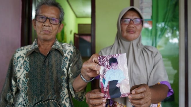 Saudah dan suaminya menunjukkan foto putra mereka, Muhammad Siddiq, yang tersapu gelombang tsunami pada tanggal 26 Desember 2004. - Hidayatullah