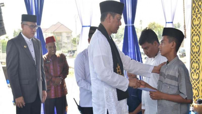 Plt Gubernur Aceh Nova Iriansyah (kiri) dan Kepala BNPB Doni Monardo saat menyantuni anak yatim dalam peringatan 15 tahun tsunami Aceh, Kamis (26/12/2019).