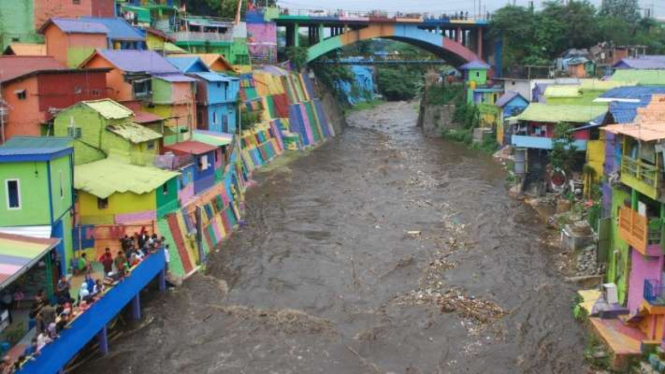 Air sungai yang deras melewati Kampung warna-warni di Malang.