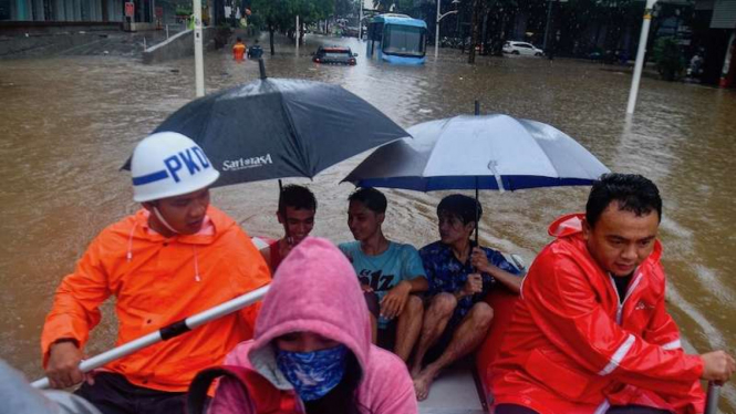 Petugas keamanan mengevakuasi warga saat banjir menggenangi Jalan Kemang Raya, Jakarta Selatan, Rabu (1/1/2020). Hujan deras yang mengguyur DKI Jakarta membuat sejumlah wilayah di Ibu Kota terendam banjir. 
