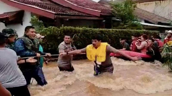 Kapolres Metro Depok dan jajarannya membantu evakuasi warga dari banjir 1 Januari 2020.