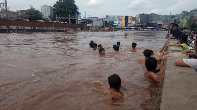 Anak- anak di Kampung Pulo Jakarta Timur berenang saat banjir Jakarta 1 Januari 2020