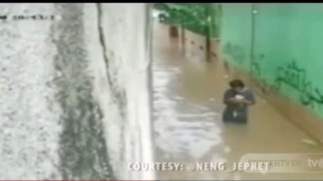 Tangkapan layar sebuah video yang mempelihatkan detik-detik seorang warga nyaris tertimpa tembok rumah yang ambruk akibat banjir di Kota Depok, Jawa Barat, Rabu, 1 Januari 2020.