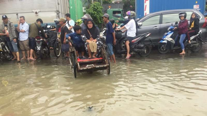 Tukang becak mengais rejeki di tengah banjir di Perumnas Bekasi 