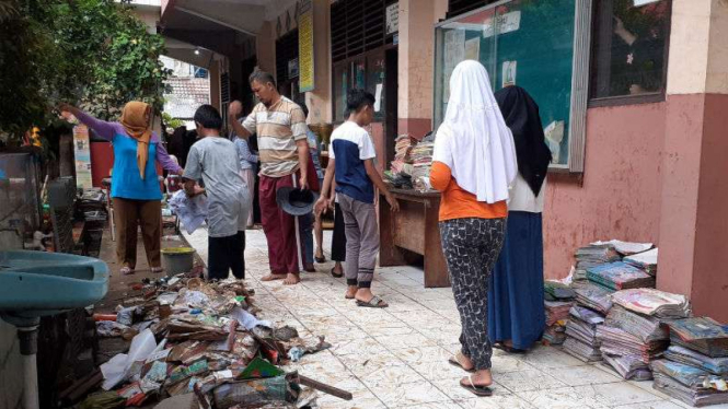 Guru dan siswa membersihkan sekolah usai dilanda banjir, di Tangerang.