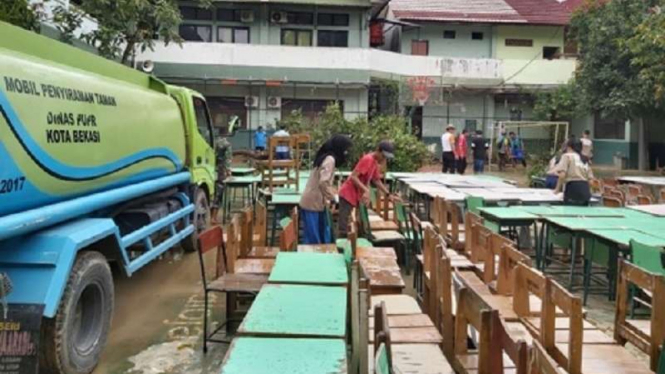 Bangku dan kursi sekolah dikeluarkan untuk membersihkan banjir