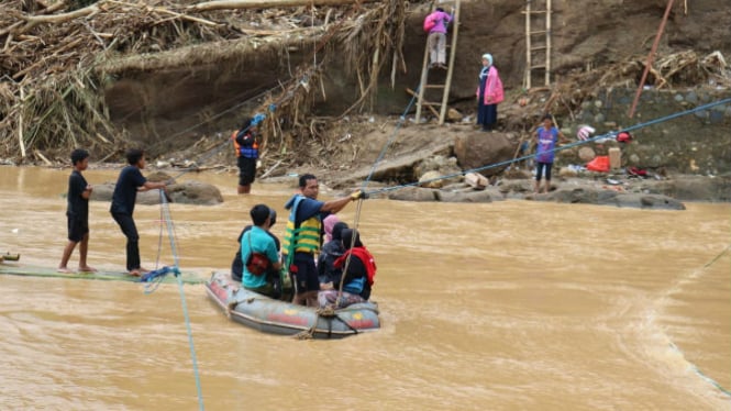 Kendaraan Bakrie Tanggap melintasi sungai berlumpur di Kampung Bujal.