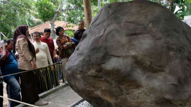 Sejumlah pengunjung menyaksikan batu prasasti di kompleks Keraton Agung Sejagat 