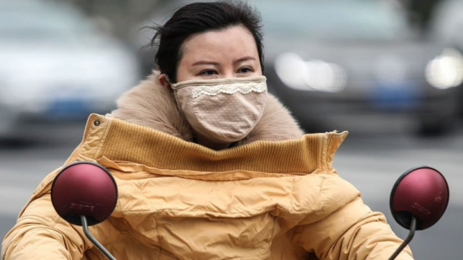 Seorang perempuan megenakan masker saat mengendarai motor di dekat pasar kuliner Huanan, Wuhan, China, di tengah merebaknya kasus virus baru misterius bernama Coronavirus, 17 Januari 2020. - Getty Images