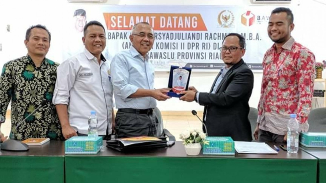 Foto: Andi Rachman menerima cinderamata dari ketua Bawaslu Riau