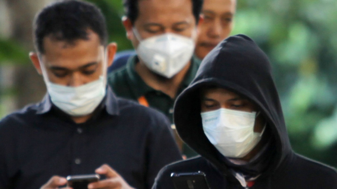 Karyawan pakai masker karena penyebaran virus Corona.