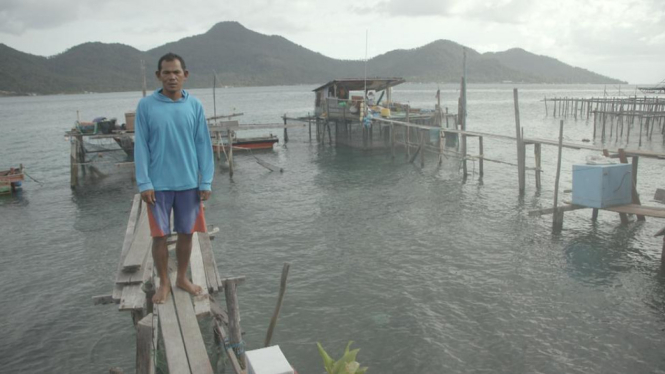 Nelayan tradisional Natuna, Sodikin menyebut kapal dan alat tangkap ikannya tidak memadai. Sodikin sedang berdiri di halaman belakang rumahnya di Pulau Tiga Barat, Kabupaten Natuna. - BBC Indonesia/ Haryo Wirawan