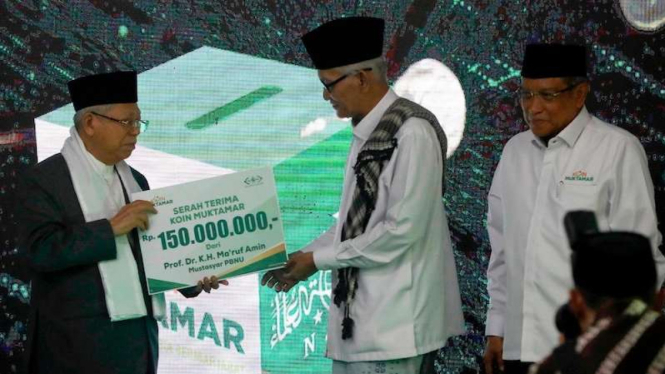 Wakil Presiden Ma'ruf Amin (kiri) menyerahkan sumbangan pada peluncuran Koin Muktamar kepada Rais Aam PBNU Miftachul Akhyar (tengah) disaksikan Ketua Umum PBNU Said Aqil Siradj saat peringatan hari lahir ke-94 Nahdlatul Ulama (NU) di Jakarta (31/1/2020). 