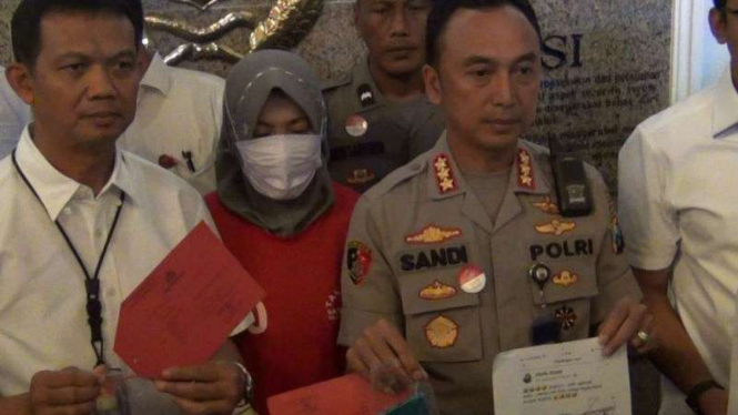 Zikria (tengah) tersangka kasus penghinaan atas Wali Kota Tri Rismaharini 