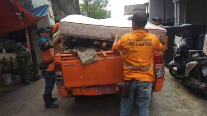 Petugas kebersihan membersihkan sampah-sampah pascabanjir.