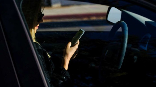 Ilustrasi mengemudi sembari bermain ponsel.