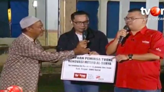 Ketua Yayasan Satu Untuk Negeri Isvan Naviansyah (kanan), disaksikan Gubernur Jawa Barat Ridwan Kamil (tengah), menyerahkan bantuan pemerisa tvOne untuk korban banjir bandang di Bogor, Jawa Barat, Jumat malam, 14 Februari 2020.