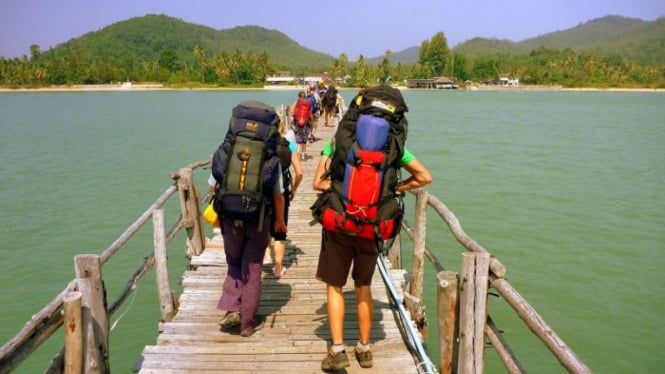 Backpackers walking over a bridge