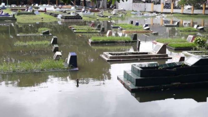 Puluhan makam di TPU Tegal Alur, Kalideres, Jakarta Barat terendam air.