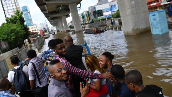 Sejumlah warga negara asing menumpang di atas sebuah truk saat banjir menggenangi Jalan Boulevard Barat Raya, Kelapa Gading, Jakarta Utara, 23/2/2020. - ANTARA FOTO/SIGID KURNIAWAN