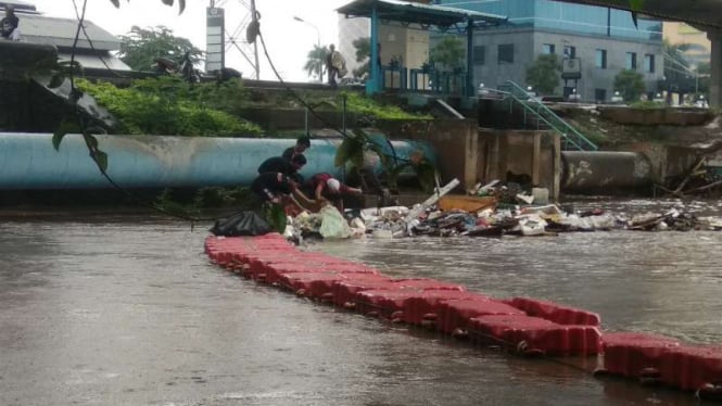 Warga Kelurahan Cipinang Melayu, Kecamatan Makasar, Jakarta Timur, membersihkan sampah di kali Sunter setelah rumah-rumah mereka kebanjiran akibat air di kali itu meluap pada Selasa, 25 Februari 2020.