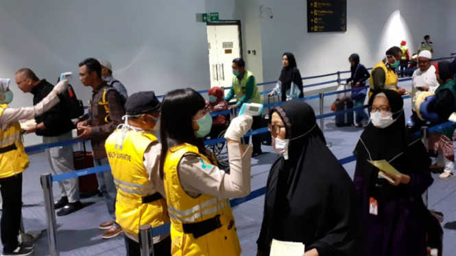 Petugas bandara Soekarno Hatta memeriksa suhu tubuh penumpang 