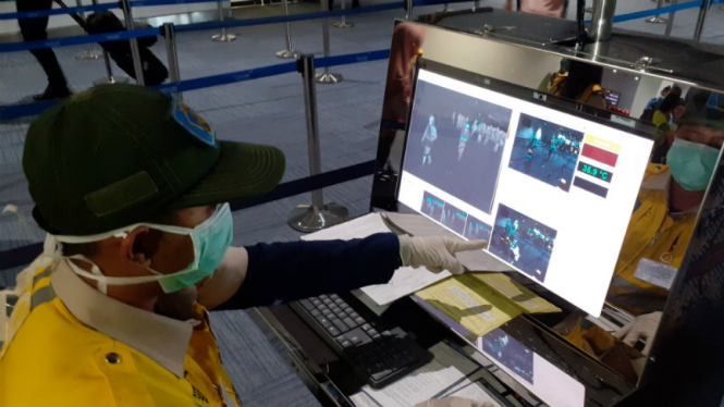Petugas Bandara Soekarno Hatta memeriksa suhu tubuh penumpang 