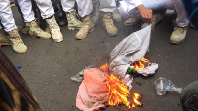 Massa membakar bendera India dalam aksi solidaritas di depan Kedubes India.