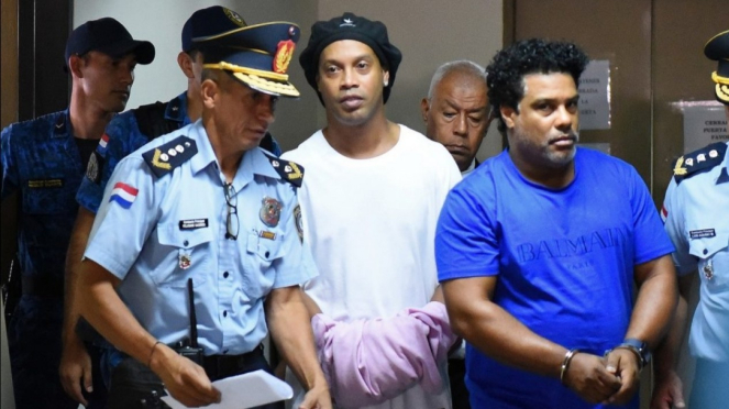 Ronaldinho dengan tangan diborgol sehabis jalani sidang di pengadilan Paraguay. 