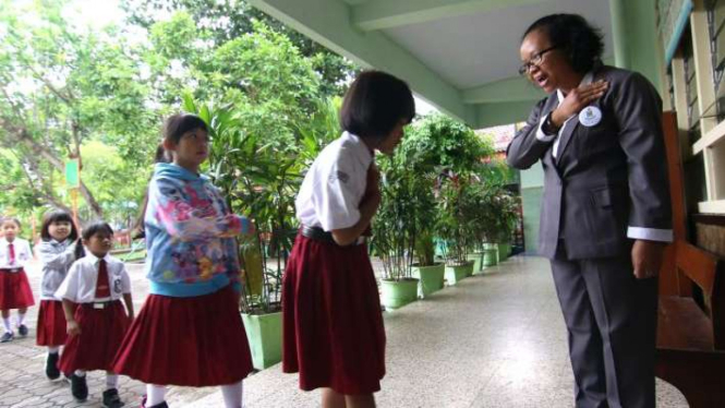 Murid memberikan salam kepada guru dengan membungkuk dan melipat tangan sebelum memasuki kelas di SDK Santa Maria, Banyuwangi, Jawa Timur, Senin (9/3/2020). Ini demi mengantisipasi dan mencegah virus Corona (COVID-19) di sekolah itu.