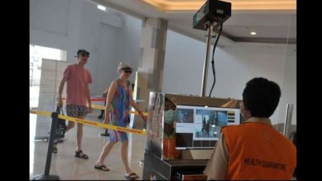Petugas memantau suhu tubuh penumpang menggunakan alat pemindai suhu tubuh yang dipasang di Terminal Penumpang Kapal Pesiar Pelabuhan Benoa, Bali, Minggu (8/3/2020). 